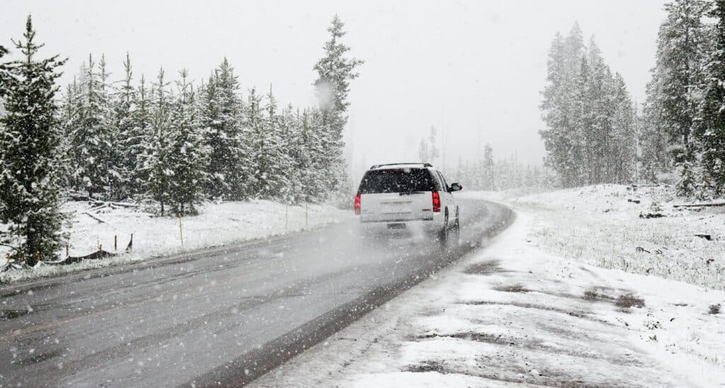 A white car on a snowy road.