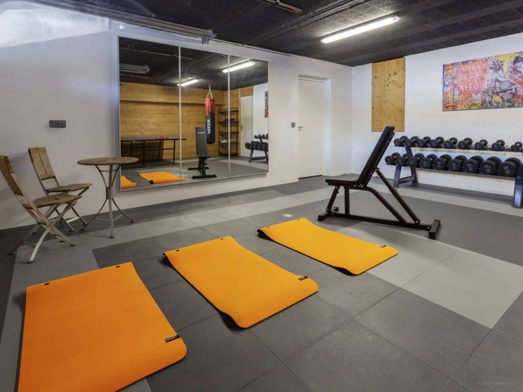 Fitness studio with orange exercise mats and gym equipment