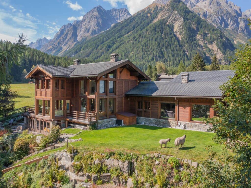 Le Chalet Cinq Moutons et son vaste jardin au cœur des montagnes.