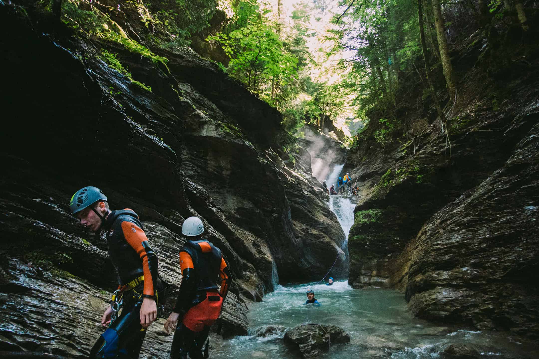 A group of people are canyoning down a river gorge