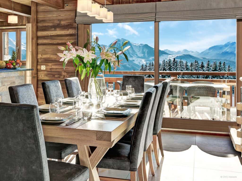 The dining table in front of a mountain view at Chalet Pralor Le Nova. 