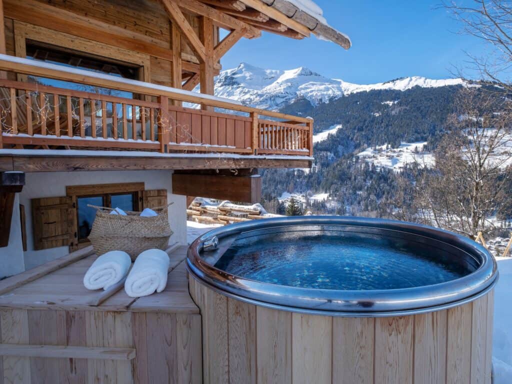 A stainless steel hot tub overlooking snowy mountains