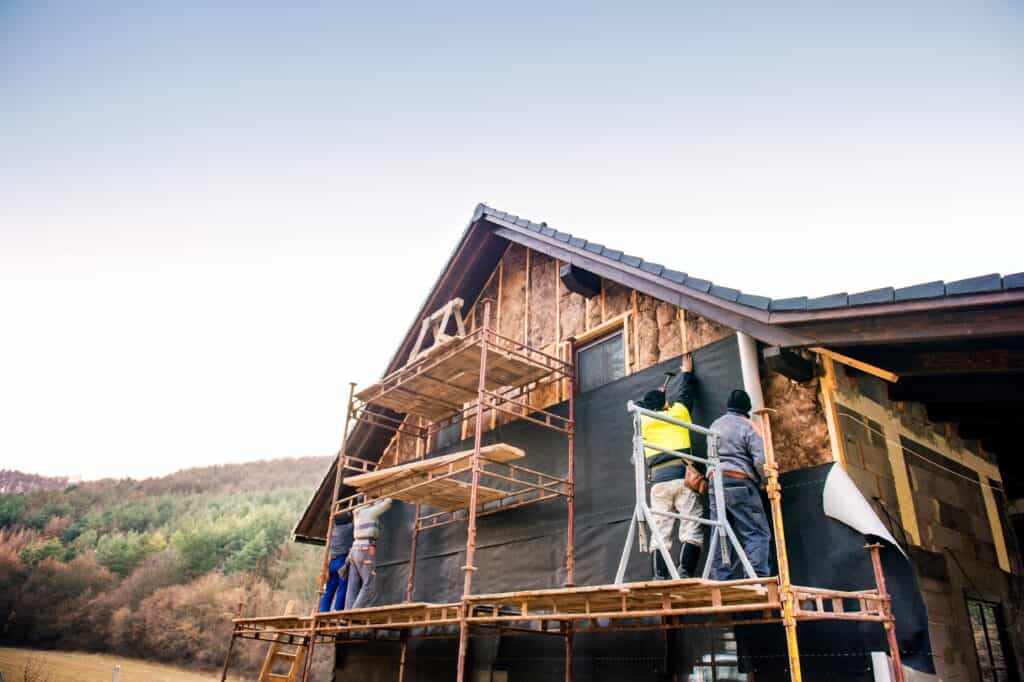 A group of builders insulate a chalet
