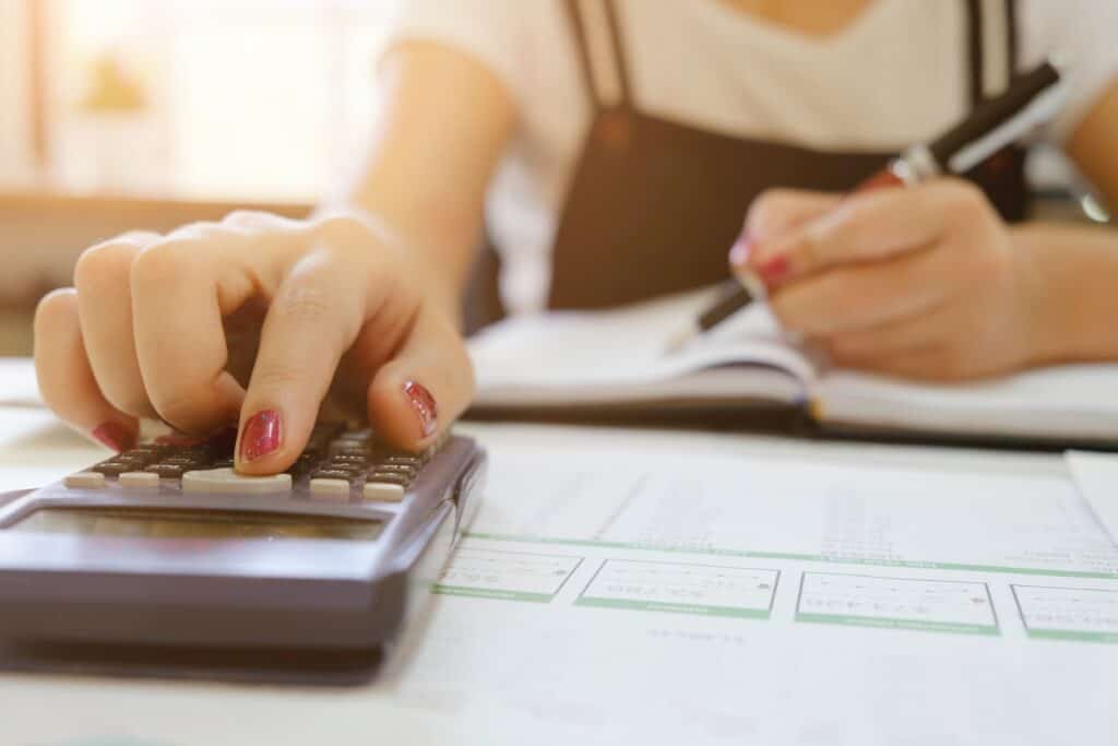 Woman types on a calculator