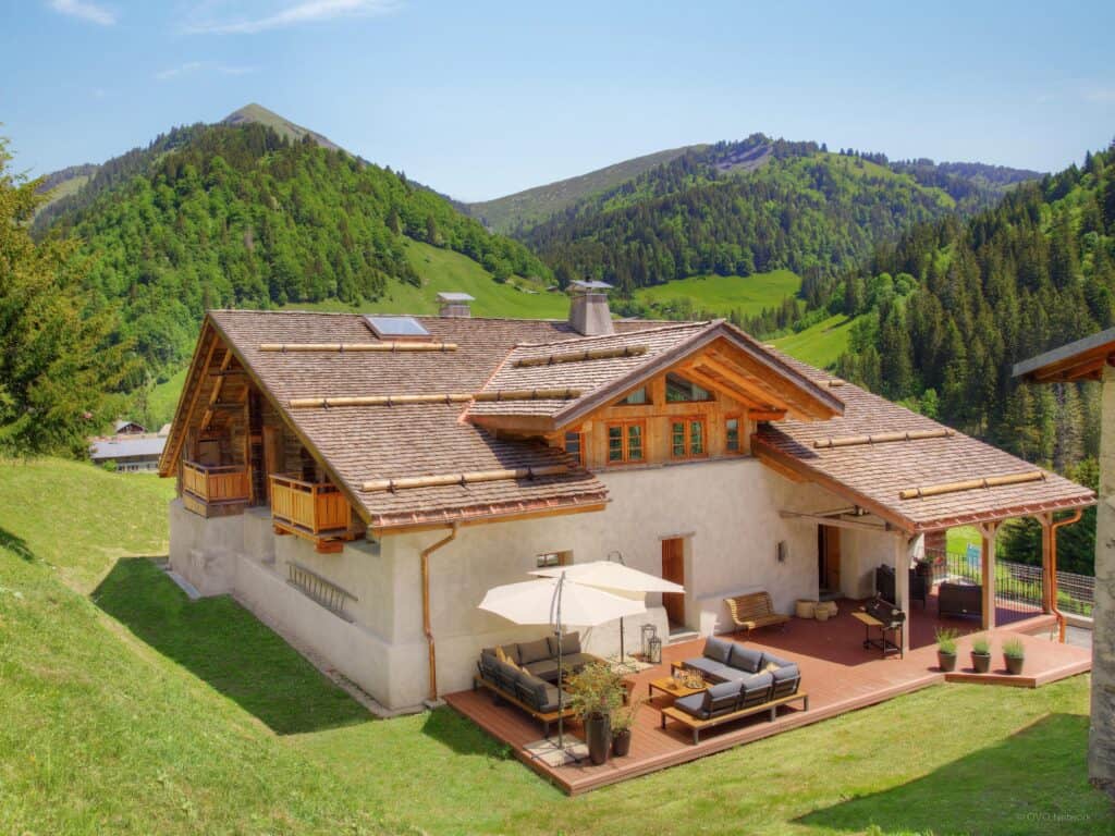 L'extérieur d'un chalet moderne, avec grande terrasse aménagée.