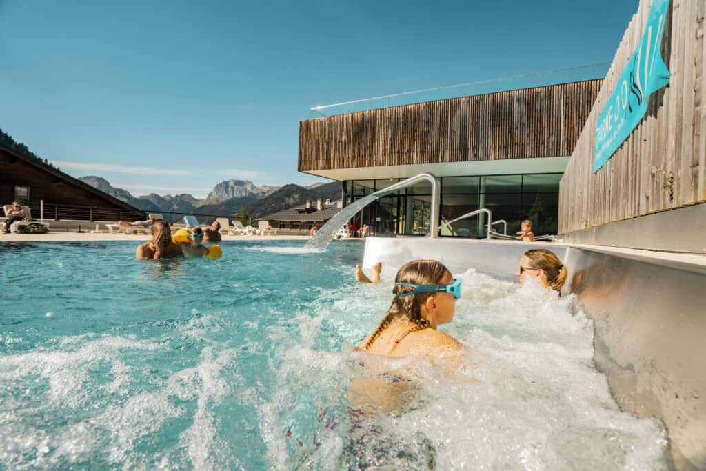 A family enjoying the pool at Chatel under a blue sky thanks to the Multipass
