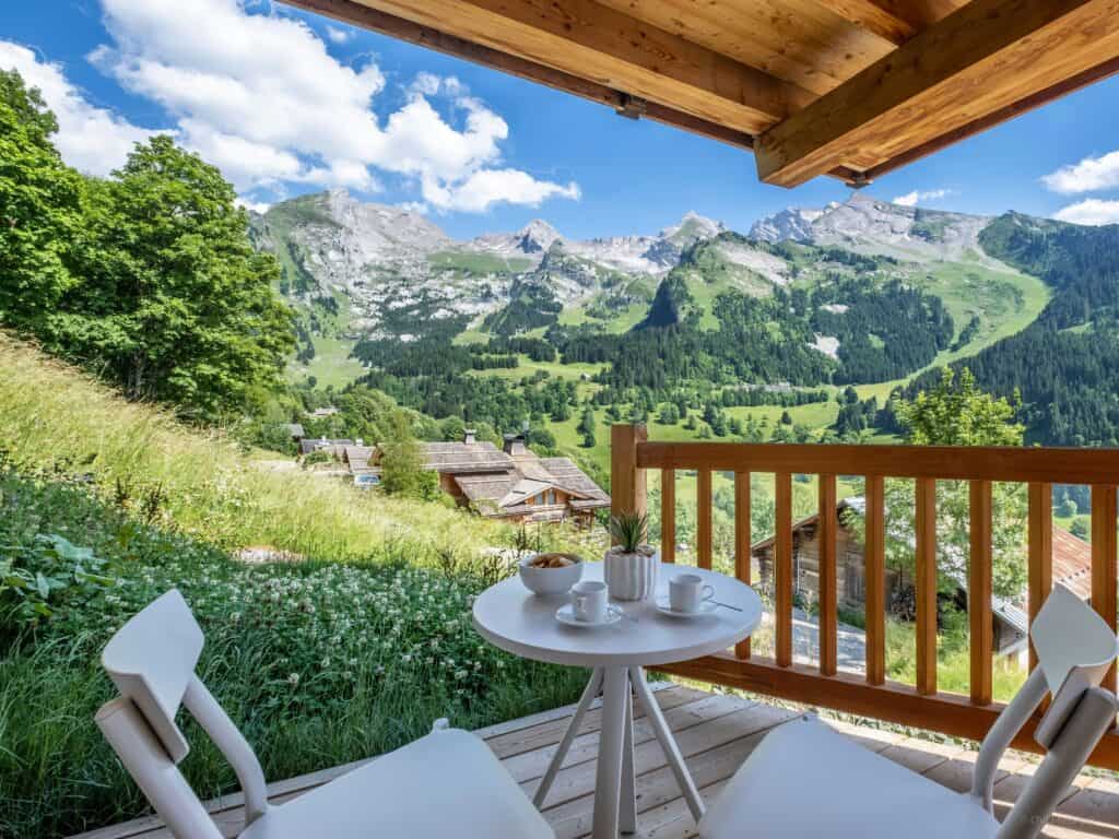 Vue sur les montagnes et le village depuis la terrasse du Chalet Bleu Infini.