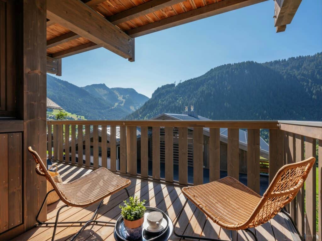 Two summer chairs facing out over sunny mountains