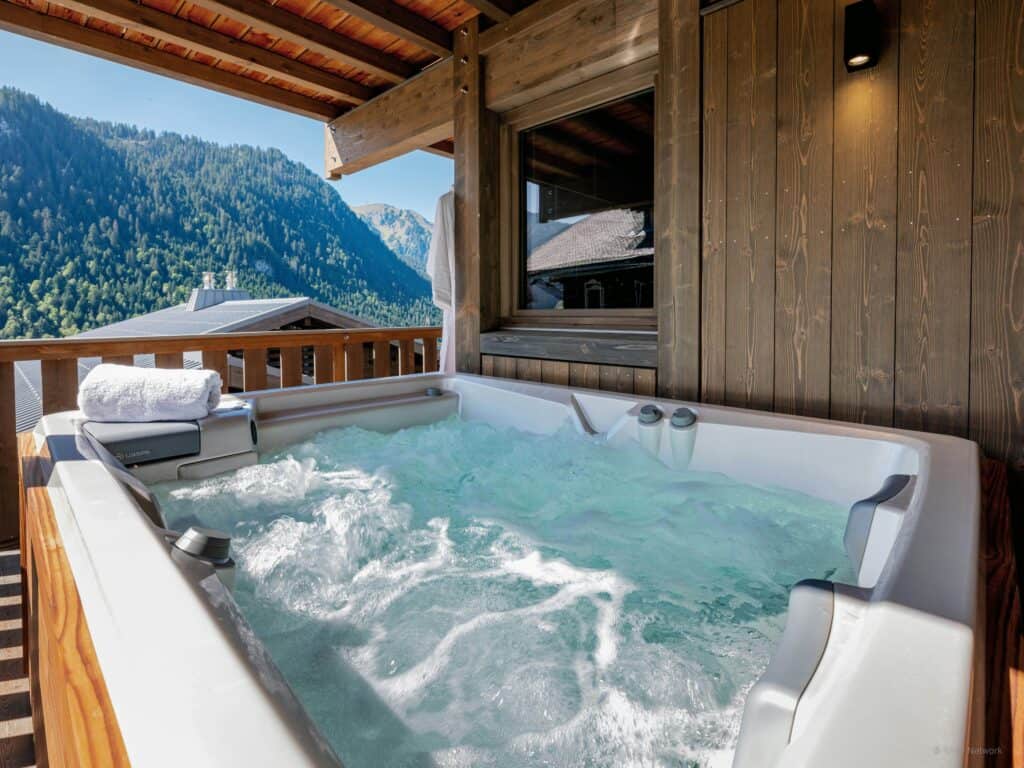 Jacuzzi extérieur avec vue sur les montagnes.