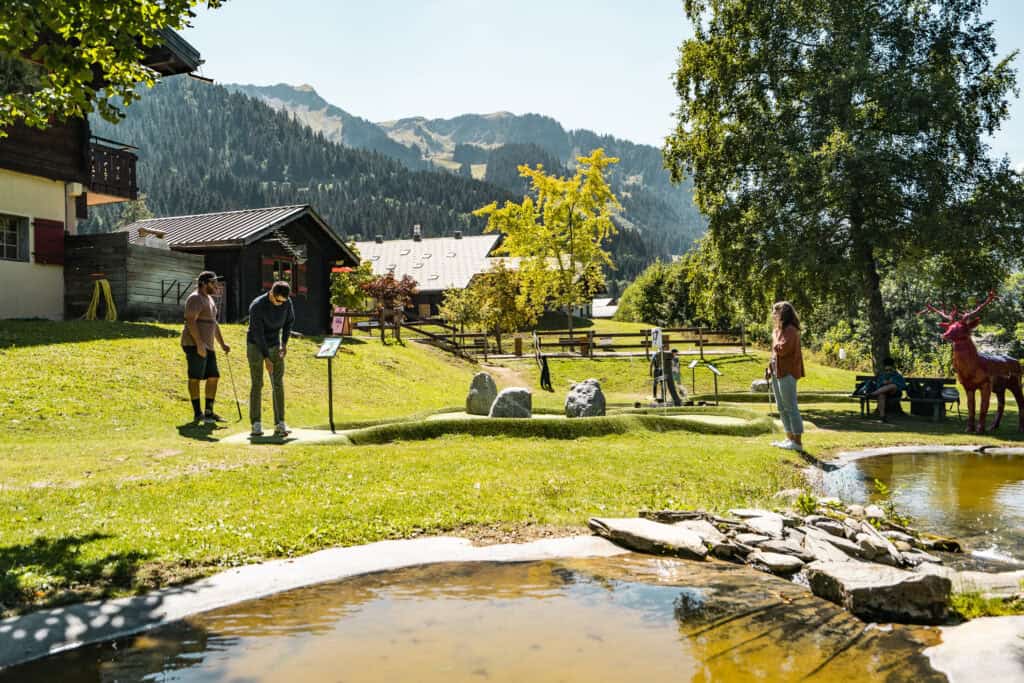 Groupe de personnes jouant au mini-golf au cœur des montagnes.