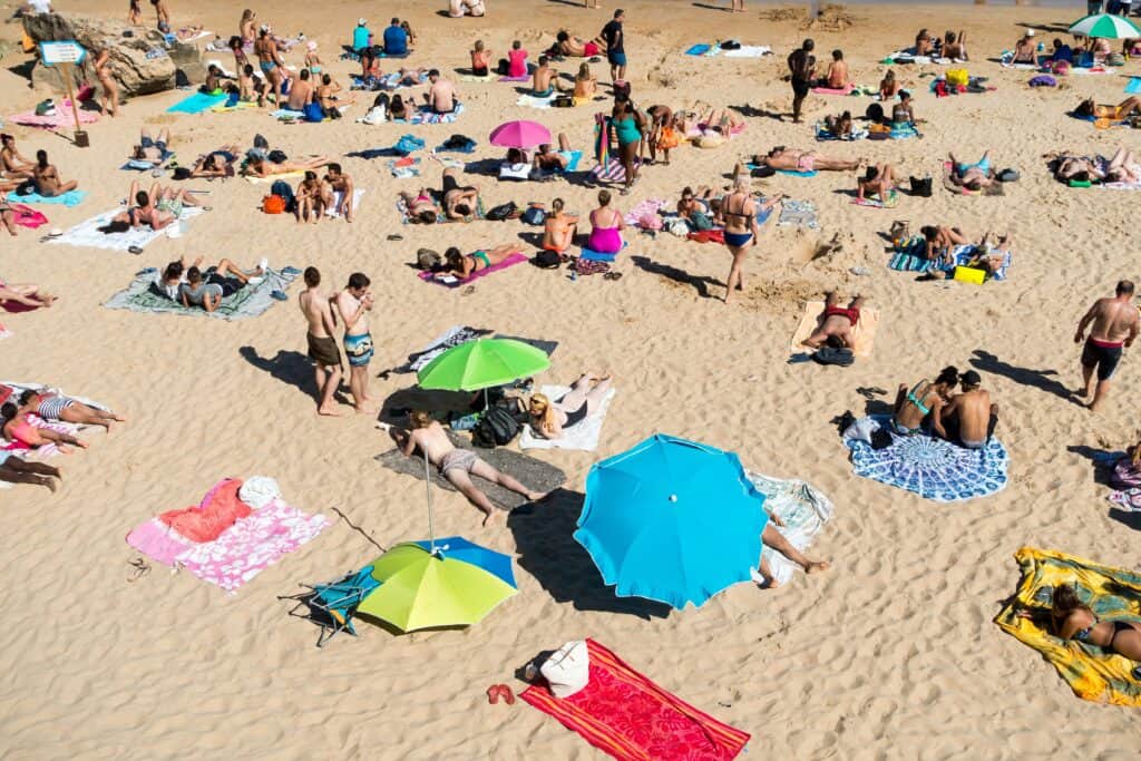 Vacanciers prenant le soleil sur une plage de sable.